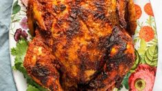 a close up of a chicken on a plate with flowers and leaves around the edges