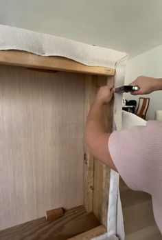 a woman is working on an unfinished cabinet