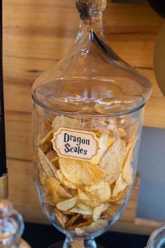 a glass jar filled with chips sitting on top of a table