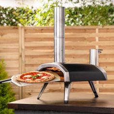 a pizza is being cooked on an outdoor grill