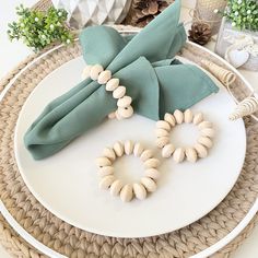 a white plate topped with green napkins and wooden beads