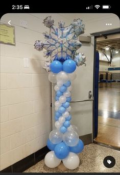 balloons and snowflakes are arranged in the shape of a tower on a marble floor