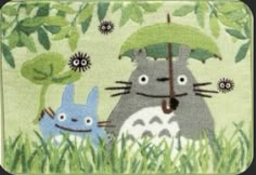 a rug with totoro and hippo in the grass holding an umbrella over their head