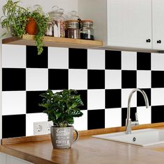 a black and white checkered kitchen wall with a potted plant on the counter