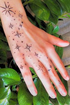 a woman's hand with stars tattooed on it