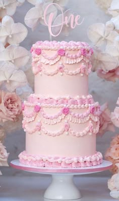 a three tiered cake with pink icing and ruffles