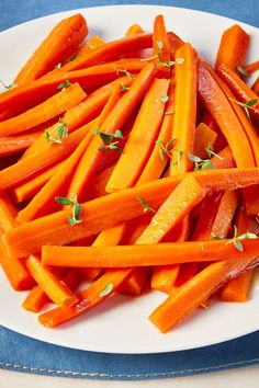 a white plate topped with sliced up carrots on top of a blue table cloth