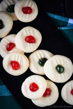 small cookies with jelly on them sitting on a black plate