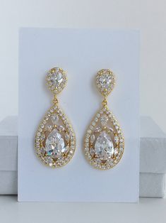 Super sparkely clear cubic zirconia bridal teardrop jewelry set in gold plated brass setting. This set includes: # Super sparkly earrings # I've created these truly amazing earrings with delicately detailed clear cubic zirconia teardrop that dangles from a cubic zirconia detailed teardrop ear stud. Total length of the earrings is 4.2 cms. # Super sparkly necklace# Necklace pendant features delicately detailed super sparkly teardrop with clear cubic zirconia crystals and dangles from cubic zircon Gold Teardrop Earrings With Diamond Accents For Wedding, Glamorous Gold Sparkling Teardrop Earrings, Elegant Gold Pear-shaped Bridal Earrings, Pear-shaped Teardrop Earrings With Diamond Accents For Wedding, Pear-shaped Diamond Accented Bridal Earrings, Pear-shaped Bridal Earrings With Diamond Accents, Gold Bridal Earrings With Sparkling Cubic Zirconia, Gold Sparkling Drop Jewelry, Gold Teardrop Crystal Earrings With Sparkling Stones