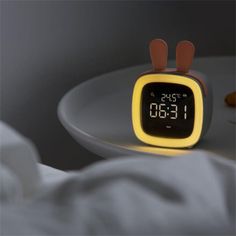 an alarm clock sitting on top of a white plate