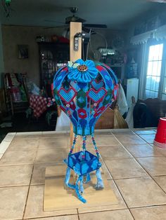 a blue and red sculpture sitting on top of a tile floor