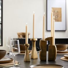 a dining room table set with candles and plates