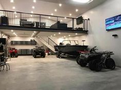 an indoor garage with two atvs and three wheelers in front of the stairs