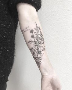 a woman's arm with a flower tattoo on it