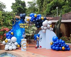 balloons and decorations are set up in front of the entrance to an outdoor party venue