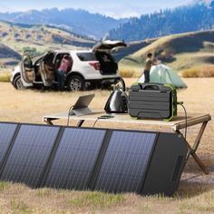 a solar panel sitting on top of a wooden table next to a car with the back door open