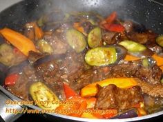 beef and vegetables cooking in a wok on the stove