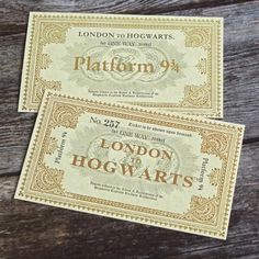 two harry potter hogwarts paper money sitting on top of a wooden table next to each other