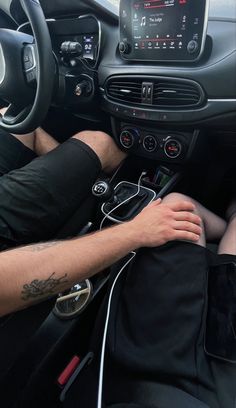 a man sitting in the driver's seat of a car with headphones on