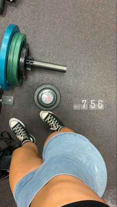 a person standing next to a pair of dumbbells with their feet on the ground