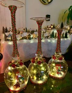 three glass vases with christmas decorations on them