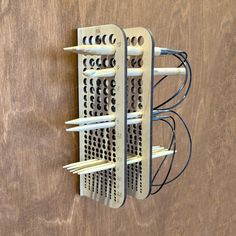 a wall mounted rack with several different items attached to it's sides on a wooden surface