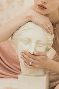 a woman is holding onto a white statue