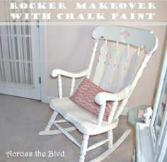 the rocking chair is painted white and has pink pillows on it's back end