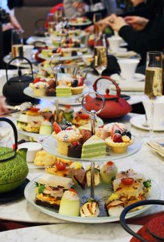 a long table filled with lots of plates and food on top of each other,