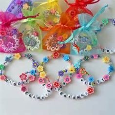 several colorful bracelets with name charms and bows on them, all decorated in different colors