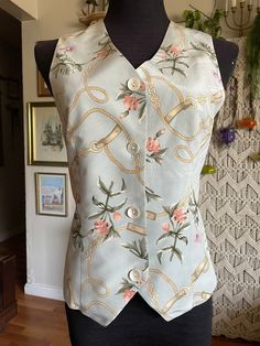 "This vest is so beautiful with very refined pastel colors  Has a delicate look Equestrian pattern with belts and flowers  Pastel colors: dusty pink, purple, ochre, green on pastel gray background  Silk 💯  Beautiful natural shell buttons  Elastic waist in the back  Size S Approximate measurements are taken flat  Armpit to armpit 17\" Waist 15\" Length in the 20\", in the front 22\" Excellent condition" Pastel Gray, Flowers Pastel, Silk Vest, Pastel Grey, Beaded Sweater, Vintage Inspired Dresses, Shell Buttons, Vest Outfits, Character Names