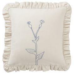 a white pillow with a blue embroidered flower on the front and back of it, along with a ruffled edge