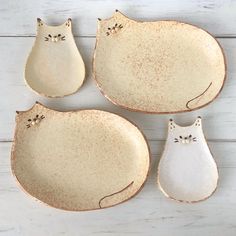 four ceramic plates with cats sitting on them