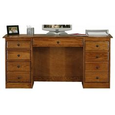 a wooden desk with drawers and a computer monitor on it's top, in front of a white background