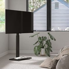 a flat screen tv sitting on top of a wooden stand in front of a window