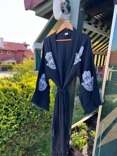 "Beautiful handmade hamsa hand black kimono robe, designed with cotton fabric, it flows as you move for a comfortable wear. Beach cover up, a kimono with hamsa hand designs. This is a lovely, good-quality kimono, with traditional breathable kimono sleeves.        A belt that ties around the waist. Great to wear around the house, on beaches, or to dress up with some jeans & a T-shirt, covering up on the beach with a swimsuit.         We love kimonos as they are so versatile. They also make really special & unique birthday, valentines Day, Christmas gifts, and Mother's Day gifts. The perfect combination of comfort and style, this kimono is a great addition to your new season wardrobe.    Cotton Fabric and Handmade      Length from shoulder: 115 CM Width: 130 CM Kimono Size: One/Standard size Black Cotton Kimono For Festivals, Black Cotton Kimono For Summer, Black Long Kimono For Beach Cover-up, Black Bohemian Cotton Kaftan, Black Cotton Bohemian Kaftan, Traditional Open Front Kaftan For Festivals, Black Bohemian Kimono For Beach Cover-up, Traditional Open Front Kimono For Festivals, Black Kimono With Relaxed Fit