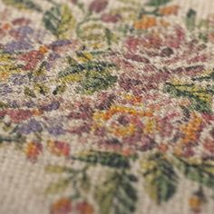 an old rug with flowers and leaves on the bottom is seen in this close up photo