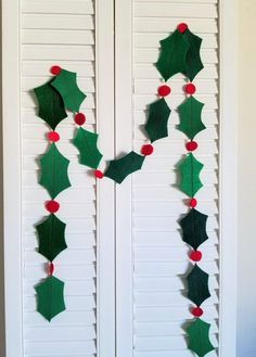 a door decorated with holly leaves and poinsettis hanging on the side of it