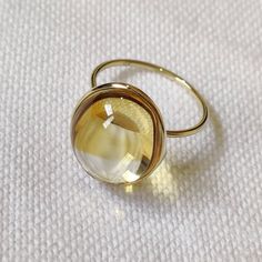 This stunning ring is set in 14k Solid Yellow Gold with Natural Citrine with utmost precision. It is a unique statement gemstone ring for nearly every occasion and is completely hassle-free jewelry. ITEM DETAILS: * GEM: Citrine * GEM SIZE: mm * GEM SHAPE: Round * Total Gem weight: 5.14 carats * Gold Purity: 14KT  * Gold Weight: 0.80 gram * Total Weight of the Ring: 1.83 gram The Gold purity is guaranteed and it comes with an authentic 14KT gold hallmark. Since my items are handmade, they are absolutely nickel and lead free. CUSTOMIZATION: * Size Customization is available for this ring and it is available in all ring sizes. Kindly choose your ideal ring size from the drop-down. * Gemstone customization is available and it can be substituted with a gem of your choice. Kindly message me for Elegant Yellow Oval Cabochon Ring, Gold Oval Cabochon Topaz Ring Gift, Gold Topaz Oval Cabochon Ring As Gift, Gold Oval Cabochon Topaz Ring, Round Yellow Gold Topaz Ring Gift, Gift Yellow Gold Topaz Ring With Bezel Setting, November Birthstone Ring, Handmade Jewelry Box, Green Amethyst Ring