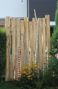 a fence made out of wooden boards and roped together with flowers in the foreground