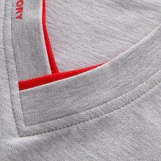 a close up view of the pocket on a t - shirt with red stitching