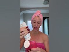 a woman with a pink towel on her head is using a hair dryer and lotion