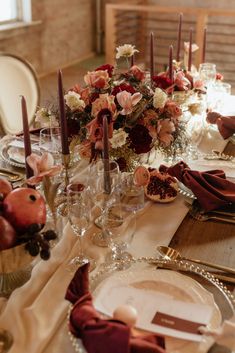 the table is set with flowers and candles