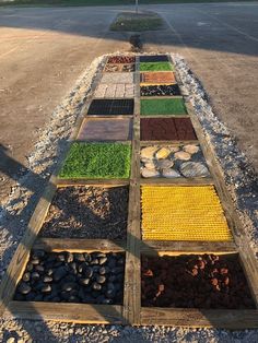 a row of different colored stones sitting on the side of a road