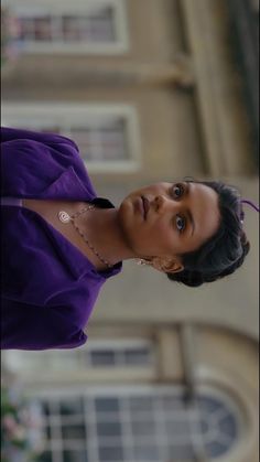 a woman in a purple dress looking up at the camera