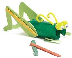 a green toy bug laying on its back next to a toothbrush and pencil holder