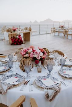 the table is set with flowers and place settings