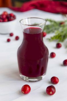 cranberry juice in a small glass with fresh cranberries around it