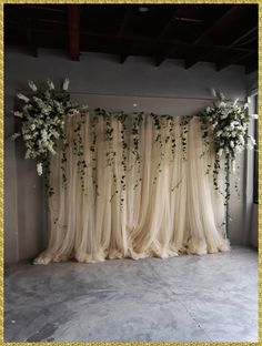 an arrangement of white flowers and greenery decorates the backdrop for a wedding ceremony