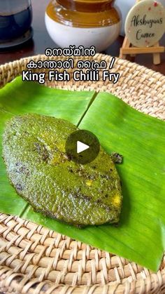 a green frog sitting on top of a leaf in front of a sign that says king fish chili fry